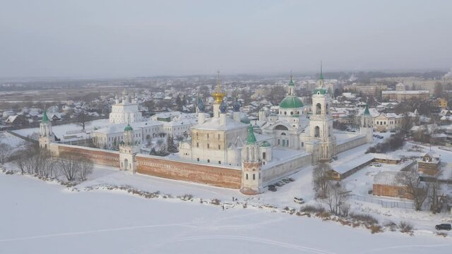 Gorgeous neoclassical Monastery of St. Jacob Saviour in a winter snowy landscape with surrounding buildings. Aerial shot on a sunset