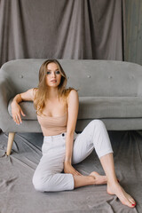 Obraz premium Woman model sits near the sofa and looks dreamily