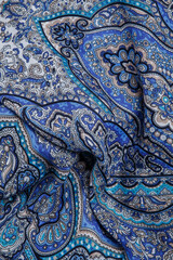 top view closeup on crumpled blue cotton scarf with oriental paisley ornament