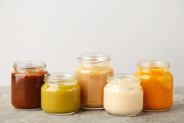 Jars of baby puree on grey background