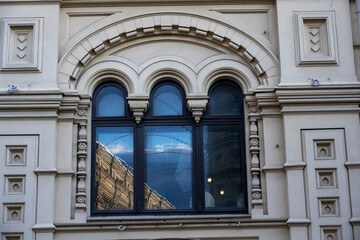 Obraz premium reflection of the sky and clouds in the windows of old houses