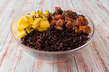 Raw Organic Tuna Poke Bowl with Rice and Veggies close-up on the table.