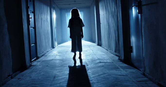 Little girl in white dress looking like a ghost carelessly running down the hallway of a haunted house - halloween costume party, horror movie 4k footage
