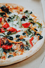 Delicious fresh pizza served on wooden table background. Summer dinner or lunch. Freshly baked Italian vegetarian pizza with vegetables. Top view.