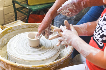 Children making pottery during ceramic lesson with clay