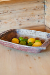 Lemons and limes in a wooden bowl