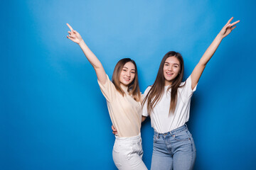 Young two women celebrate on blue background