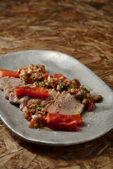 leichtes Grill Rezept mit Schwein, Wassermelone und Chimichurri auf Holztisch mit braunem Hintergrund