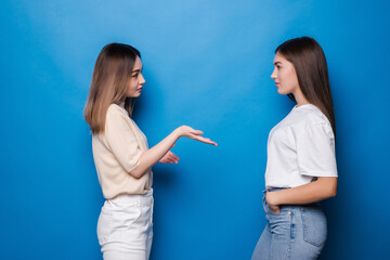 Portrait of girls talking spending time isolated on blue background