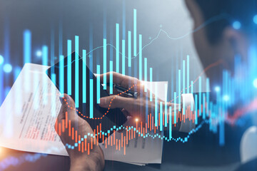 Trader in office working with Smartphone, FOREX graph hologram to analyze market behavior, typing phone. Double exposure.