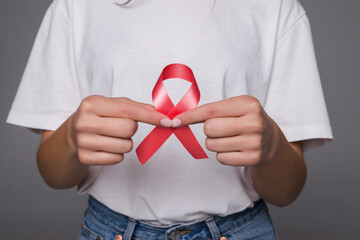 World Breast Cancer Day Concept. Health care woman wore white t-shirt with red ribbon for...