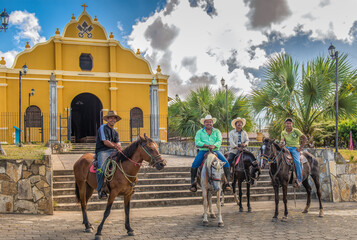 4 men on horseback in front of The Church of San Pedro, In the center of Diria, a small town near Granada Nicaragua   - Powered by Adobe
