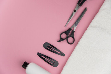 Professional hair dresser tools with copy space. Hair stylist equipment set on pink background. Scissors, brush, hairbrush, balm flat lay top view.