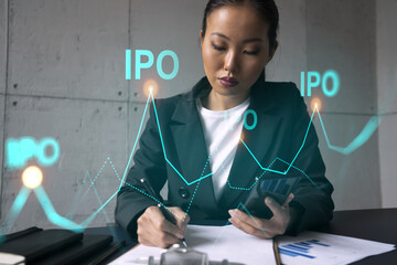 Businesswoman taking notes and IPO hologram. Double exposure. Business technology initial primary offering solution concept.