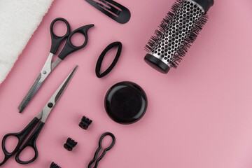 Professional hair dresser tools with copy space. Hair stylist equipment set on pink background. Scissors, brush, hairbrush, balm flat lay top view.