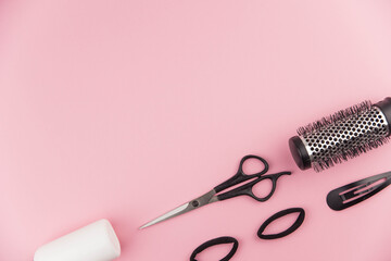 Professional hair dresser tools with copy space. Hair stylist equipment set on pink background. Scissors, brush, hairbrush, balm flat lay top view.