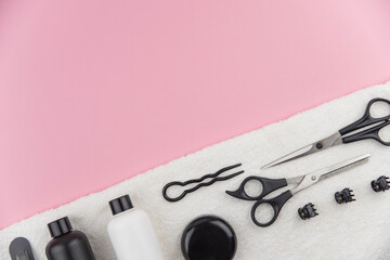 Professional hair dresser tools with copy space. Hair stylist equipment set on pink background. Scissors, brush, hairbrush, balm flat lay top view.