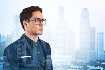 Fototapeta na wymiar Young handsome businessman in suit and glasses dreaming about new career opportunities after MBA graduation. Singapore on background. Double exposure.
