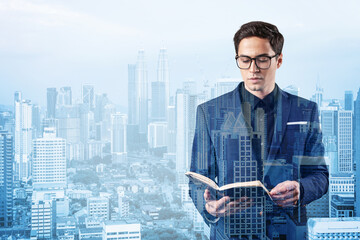 Young handsome businessman in suit and glasses thinking how to tackle the problem, new career opportunities, MBA assignment. Kuala Lumpur on background. Double exposure.