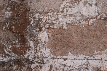 A large fragment of the clay wall of the old house with cracks and roughness, as well as fallen parts of plaster. Straw mixed with clay as building material for the wall, building houses in the past.