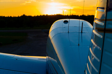 Quadruple aircraft parked at a private airfield. Rear view of a plane with a propeller on a sunset...