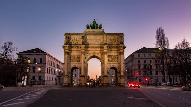 Germany, Munich - The Siegestor Victory Arch at sunset with traffic going around the arch day to night transition timelapse