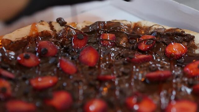 Drizzling Chocolate Sauce Atop Of A Homemade Chocolate And Strawberries Pizza Dessert