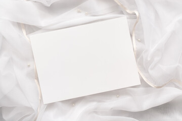 Mock up of blank paper cards for wedding invitation on tulle with pearl beads.Modern delicate...