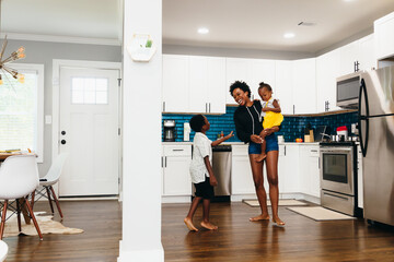 Family playing and dancing in the kitchen at home