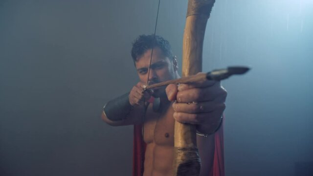 Bow and arrow in hand of roman hunter.
