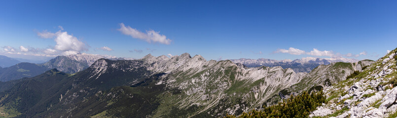 Panorama of European alps from the top of the mountain, with blue sky and few clouds. 