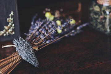 Black Kyanite crystal rock placed on dark brown wooden witch's table. Macro shot with blurred...