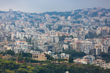 Obraz premium Dense development of Lebanese towns. Hills covered with a lot of houses. Panoramic view of villages in Lebanon