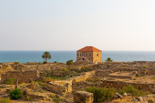 Excavation of Byblos, Lebanon. Traditional Lebanese house on the shores of the Mediterranean Sea. Seascape with blue water at sunset. Numerous stone walls of ancient structures