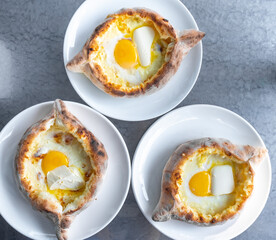 Adjarian khachapuri with eggs and butter on the table