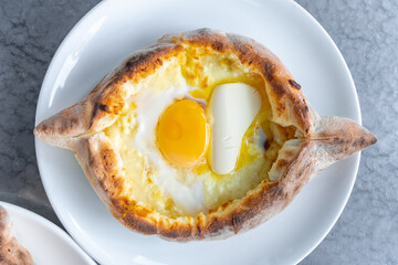 Adjarian khachapuri with eggs and butter on the table