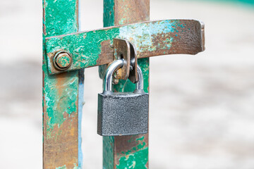 Closed and locked door grill with silver padlock.
