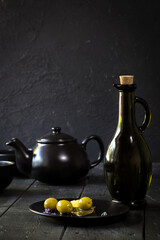 green olives on plate on black background