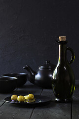 green olives on plate on black background