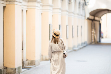 Naklejka premium A young girl walks through the streets of the old city. Foreigner travel across St. Petersburg, Russia. Romantic walks along the vintage streets.