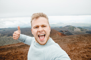 Tourist takes selfie on top of volcano Mount Etna, Sicily Italy. Mountain travel concept