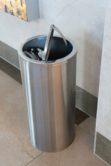Steel cylindrical waste bin with round lid.