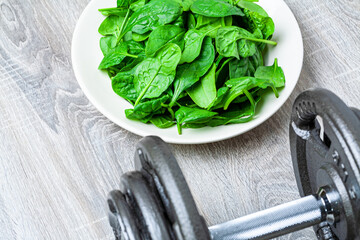 Set of weights and baby spinach on a plate