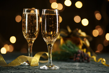 Ribbon, baubles and wine against Christmas lights.