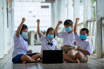 Group of Asian elementary school students wearing hygienic mask to prevent the outbreak of Covid 19 while back to school reopen their school.