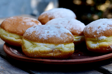 Butter rolls covered with powdered sugar are on a plate.