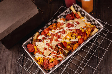delicious crazy potatoes from colombia. made with french fries, chicken, cheese, and sausages with sauce (crazy potatoes)