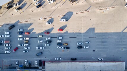 Aerial view of  park station and parked vehicles. Shopping mall parking lot.