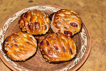 Butter buns with raisins are on a plate.