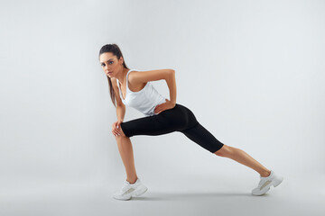 Fototapeta na wymiar Fit woman stretching her leg to warm up - isolated over background
